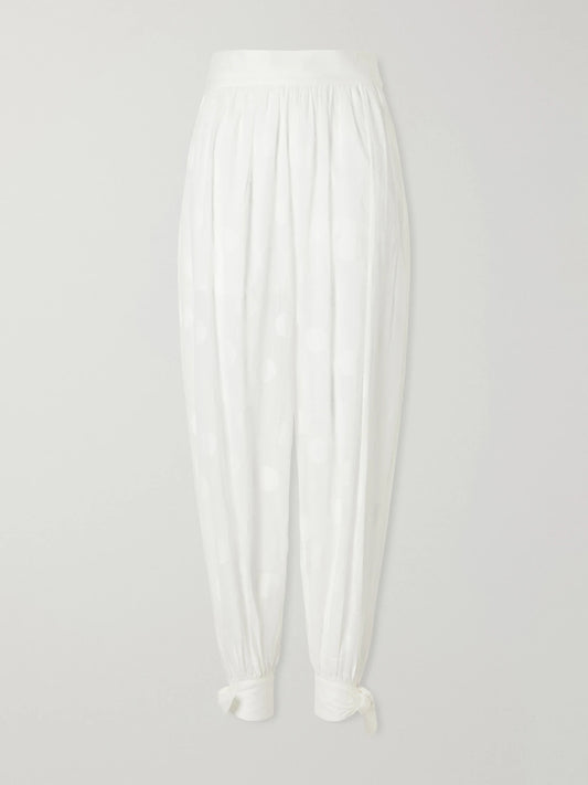 Image of a model wearing Pants. Product name - Solstice Knotted Polka-dot Cotton-poplin Balloon Pants in Ivory colour by brand - Zimmermann