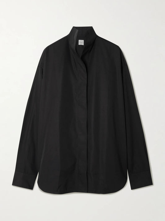 Image of a model wearing Tops. Product name - Sharp Oversized Cotton-poplin Shirt in Black colour by brand - TOTEME