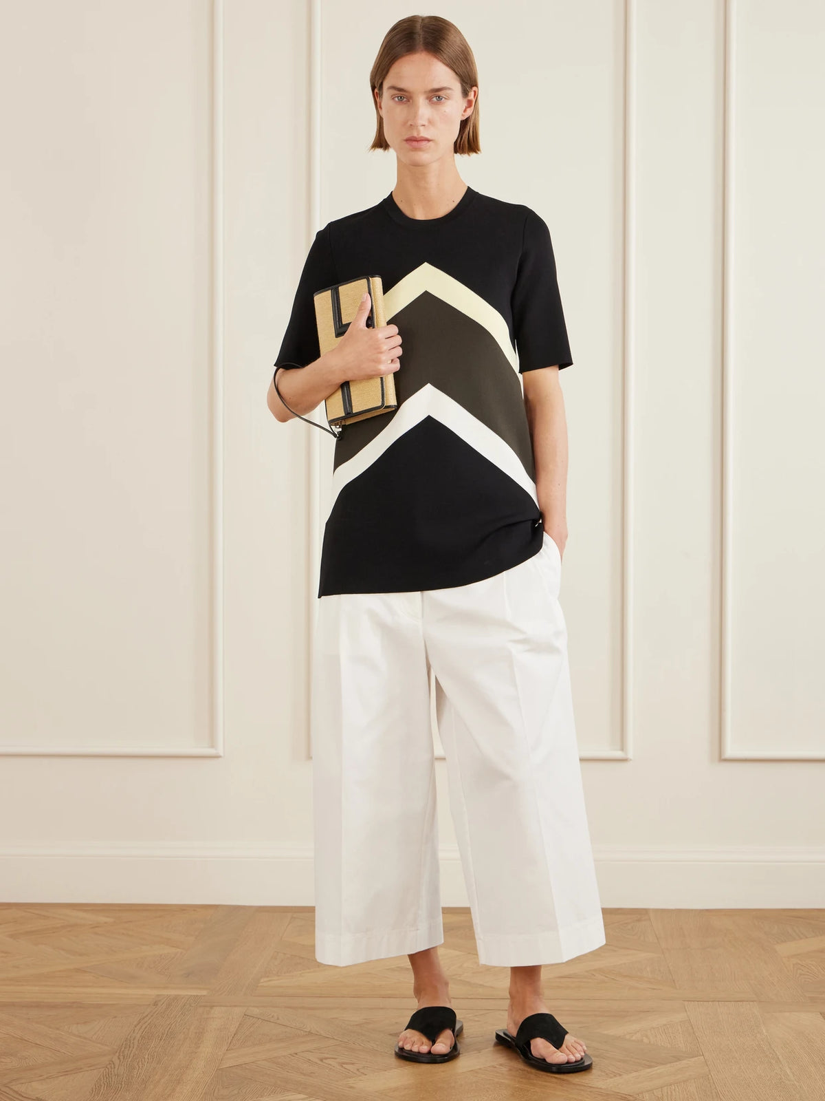 Image of a model wearing Tops. Product name - Striped Jersey T-shirt in Black colour by brand - TOTEME