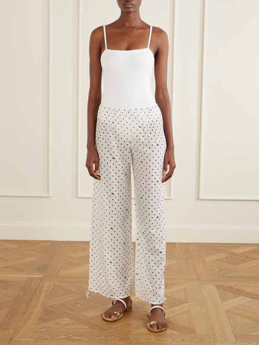 Image of a model wearing Pants. Product name - Kiki Polka-dot Cotton And Silk-blend Balloon Pants in White colour by brand - Kiki de Montparnasse