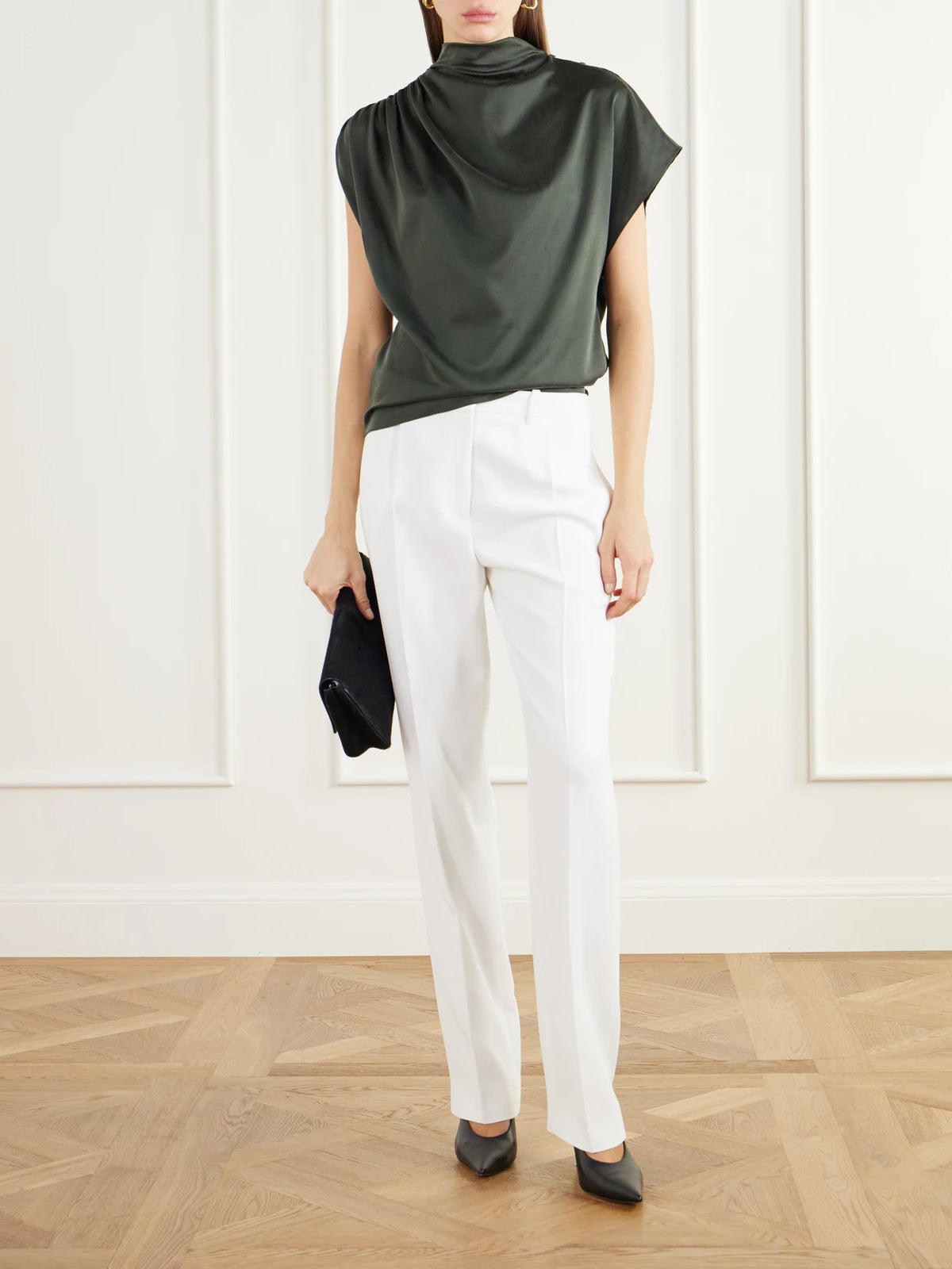 Image of a model wearing Pants. Product name - The Irving Pleated Crepe Tapered Pants in Ivory colour by brand - Brandon Maxwell