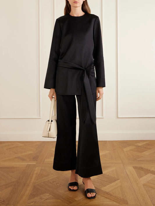 Image of a model wearing Pants. Product name - Satin Wide-leg Pants in Black colour by brand - TOTEME