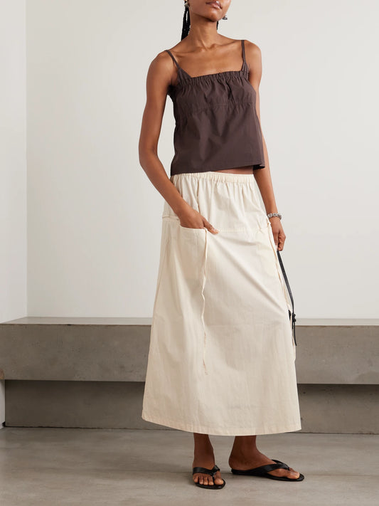 Image of a model wearing Skirts. Product name - Loop Organic Cotton Midi Skirt in Off-white colour by brand - Deiji Studios