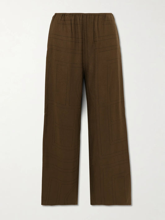Image of a model wearing Pants. Product name - Embroidered Tencel Lenzing Modal Pants in Dark brown colour by brand - TOTEME