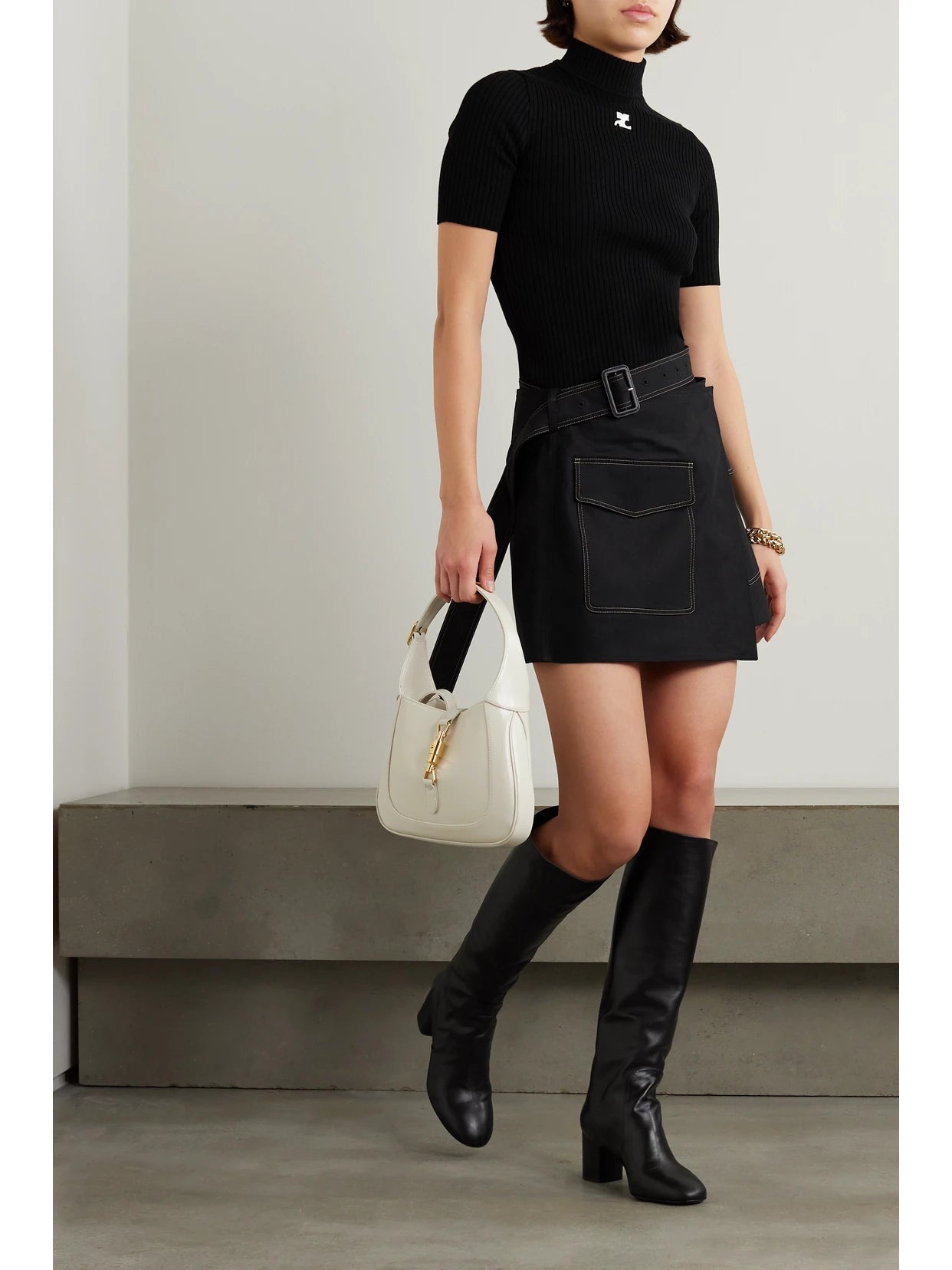 Image of a model wearing Outerwear. Product name - Embroidered Ribbed-knit Top in Black colour by brand - COURREGES