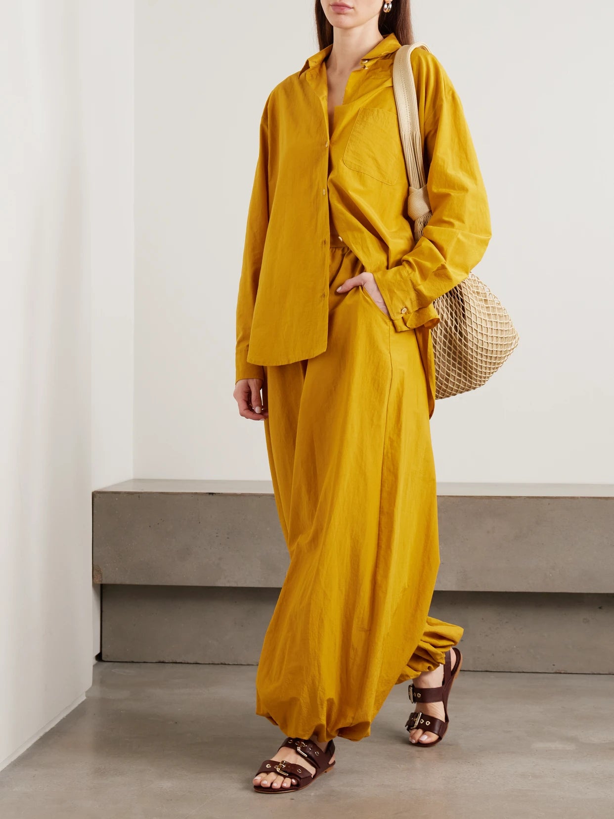 Image of a model wearing Tops. Product name - The Essential Cotton And Silk-blend Shirt in Yellow colour by brand - Jamie Haller