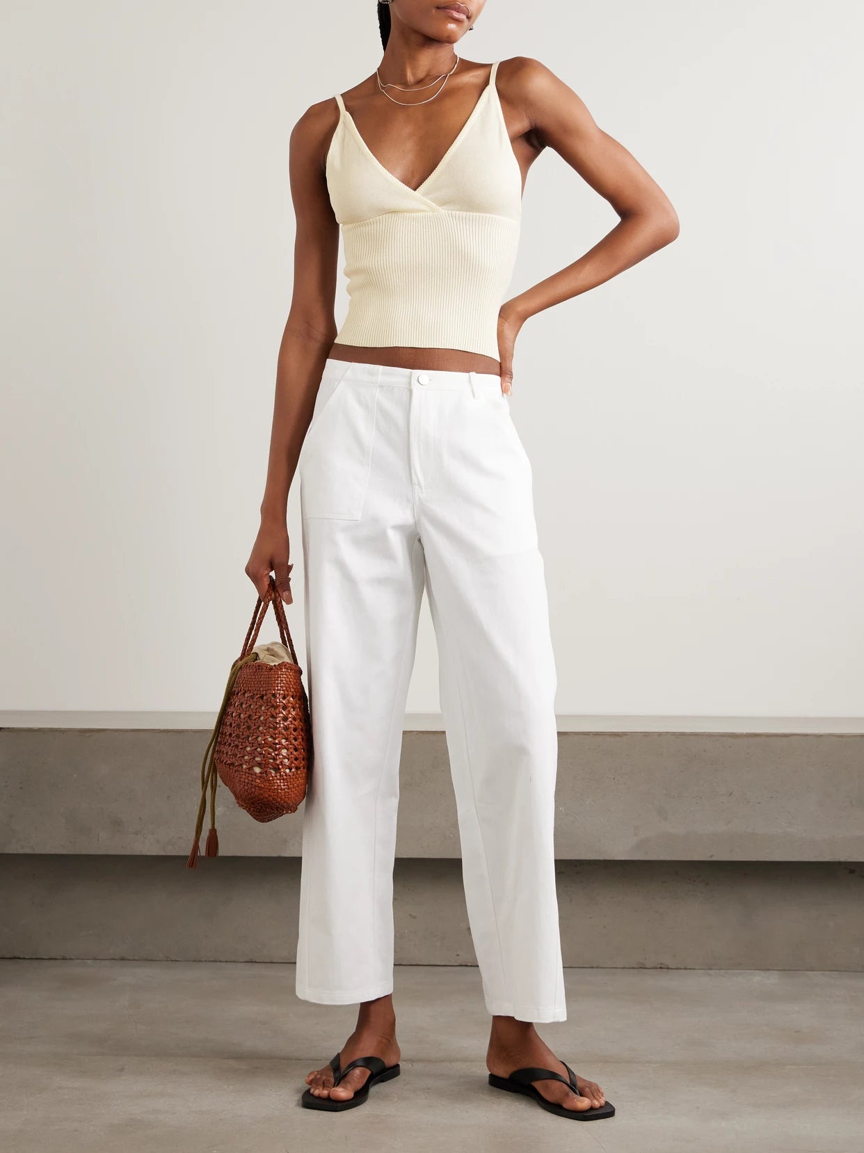 Image of a model wearing Tops. Product name - Cross Panel Cropped Ribbed Linen Top in Off-white colour by brand - Deiji Studios