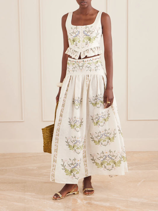 Image of a model wearing Tops. Product name - Eslabon Anhelo Floral-print Button-embellished Linen Cropped Top in Cream colour by brand - Agua by Agua Bendita