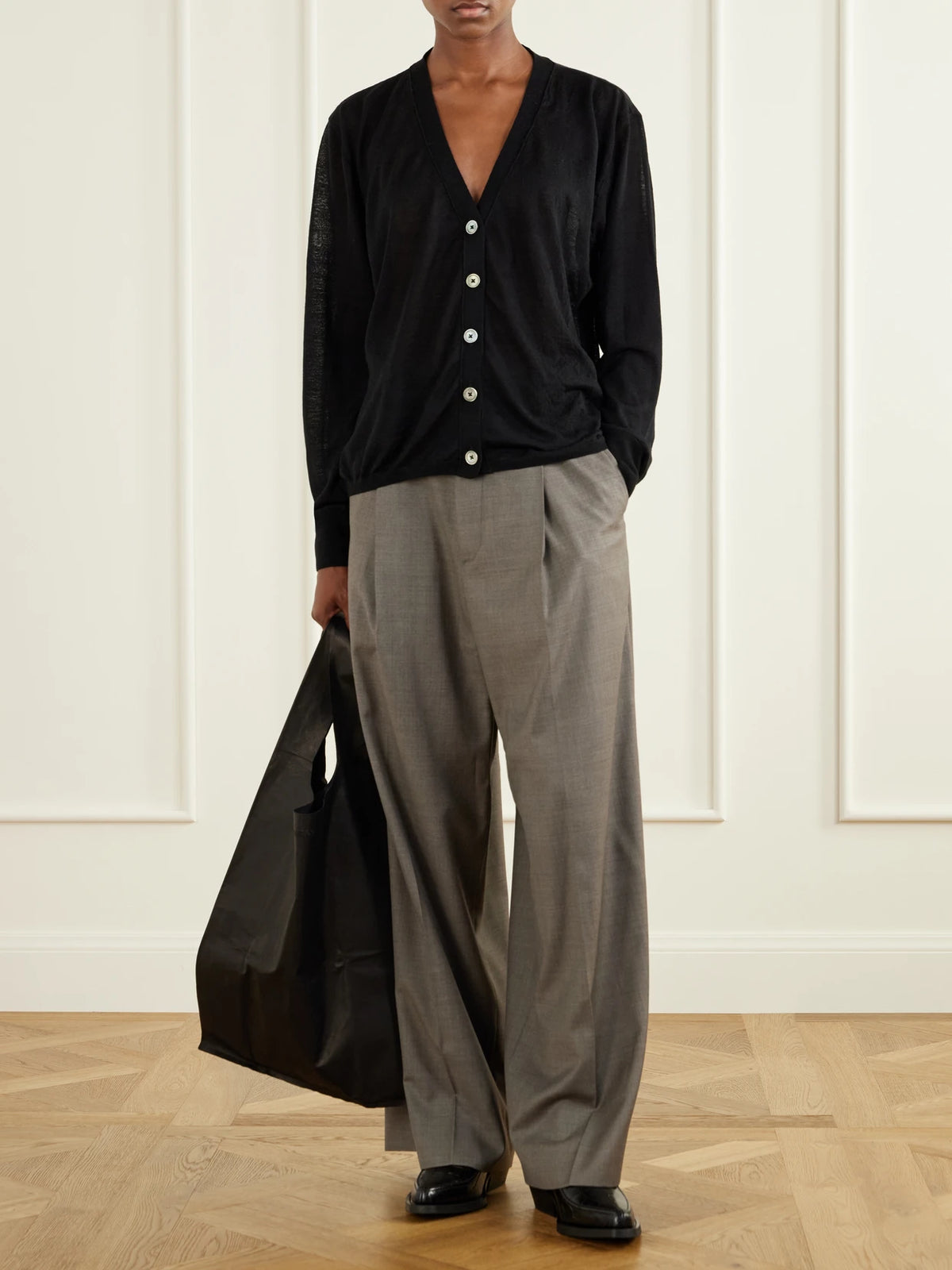 Image of a model wearing Outerwear. Product name - Slouch Merino Wool Cardigan in Black colour by brand - Our Legacy