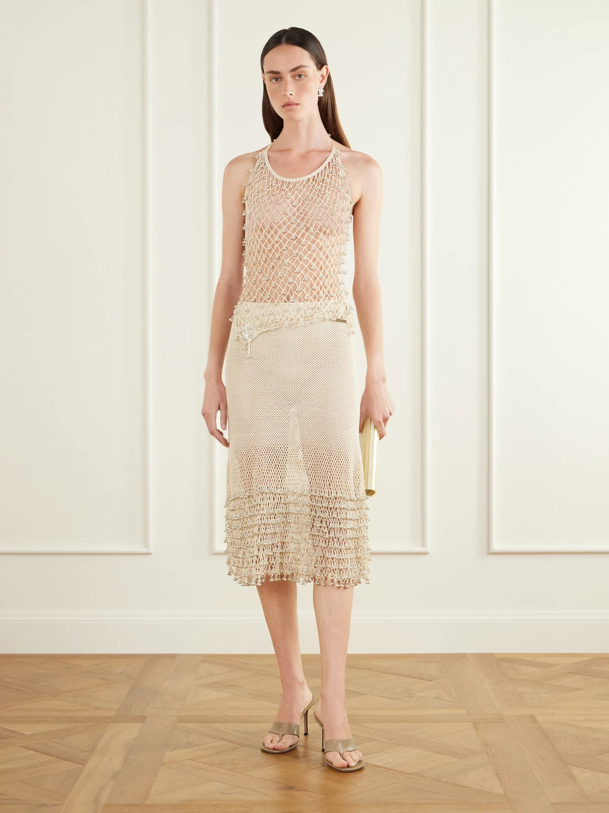 Image of a model wearing Skirts. Product name - Amandine Embellished Cotton Crochet-knit Midi Skirt in Cream colour by brand - Yoshita 1967