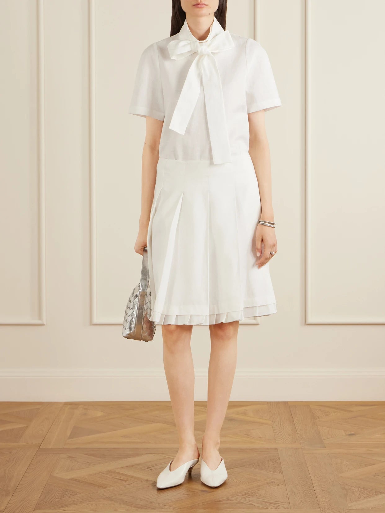 Image of a model wearing Tops. Product name - Bow-detailed Linen Blouse in White colour by brand - SHUSHU/TONG