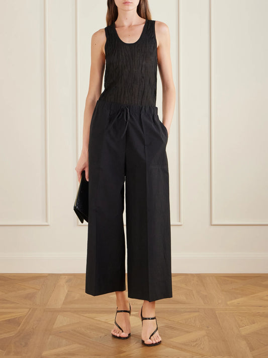 Image of a model wearing Pants. Product name - Wide Summer Cotton-blend Wide-leg Pants in Black colour by brand - TOTEME