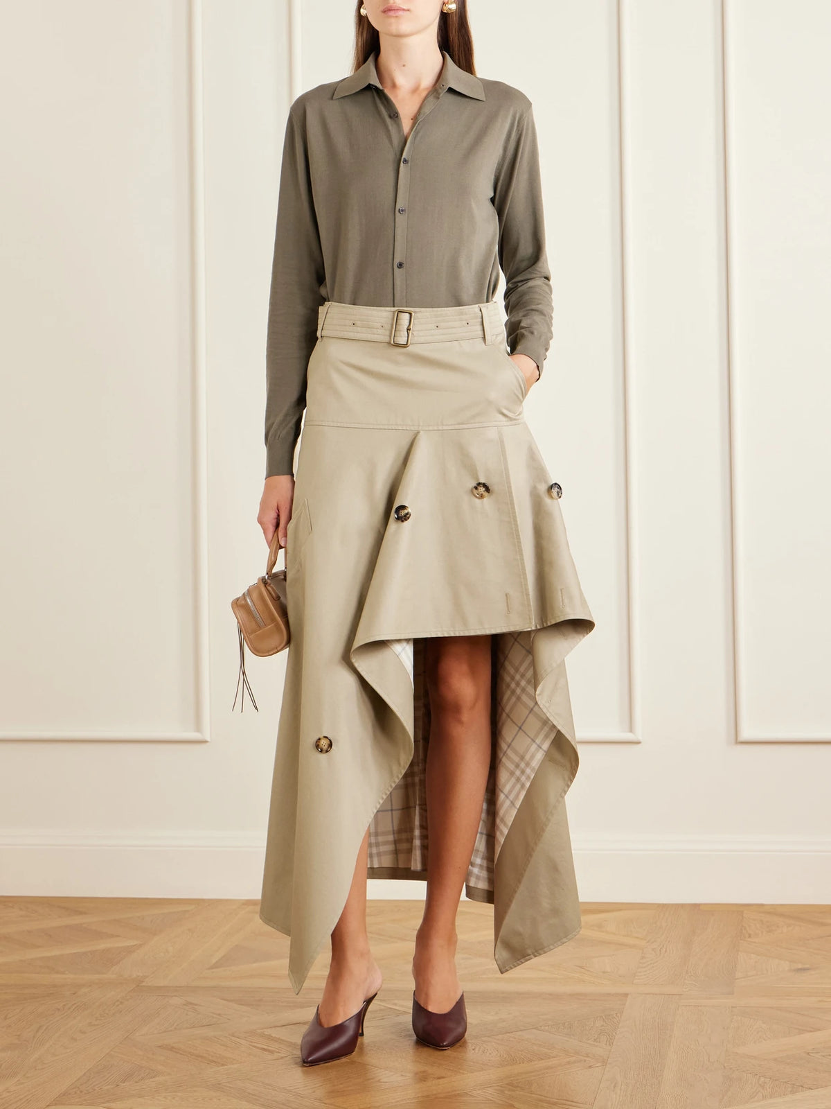 Image of a model wearing Skirts. Product name - Heather Belted Asymmetric Cotton-gabardine Midi Skirt in Beige colour by brand - Burberry