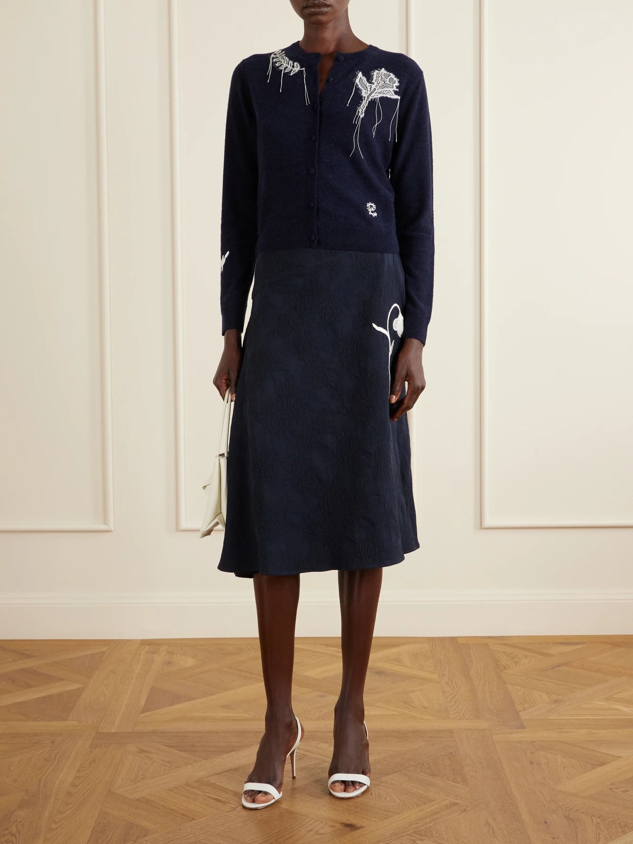 Image of a model wearing Skirts. Product name - Asymmetric Floral-jacquard Cotton-blend Midi Skirt in Navy colour by brand - Erdem