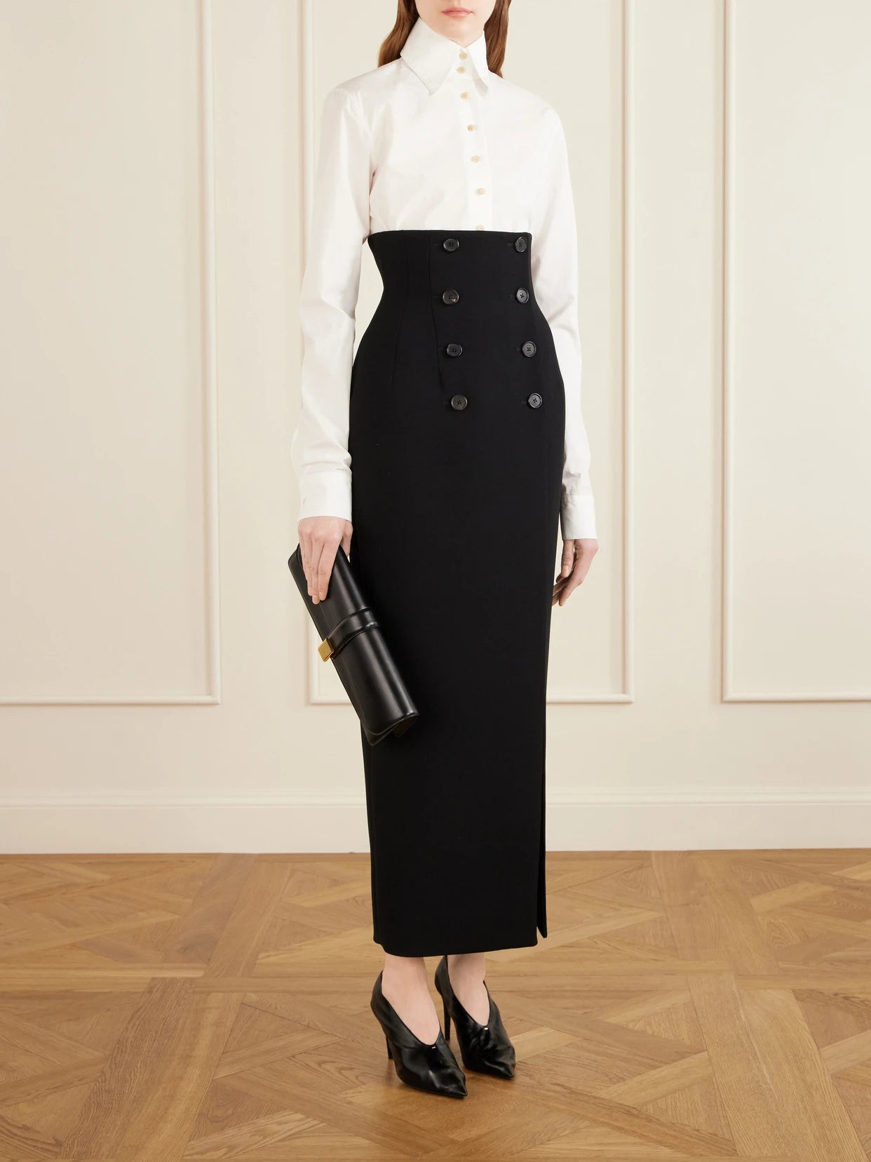 Image of a model wearing Skirts. Product name - Luiza Crepe Midi Skirt in Black colour by brand - KHAITE