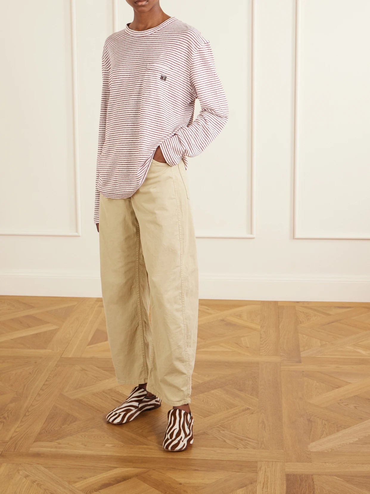 Image of a model wearing Tops. Product name - Hour Embroidered Striped Linen And Cotton-blend T-shirt in Pink colour by brand - Wales Bonner