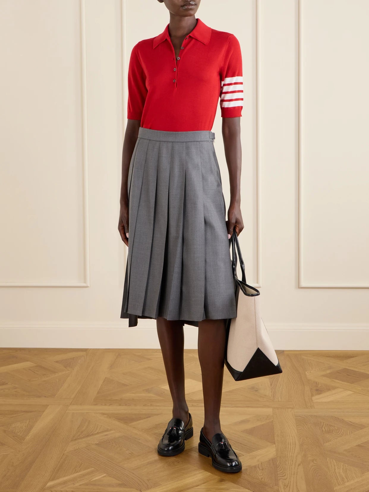 Image of a model wearing Skirts. Product name - Asymmetric Grosgrain-trimmed Pleated Wool Midi Skirt in Gray colour by brand - Thom Browne