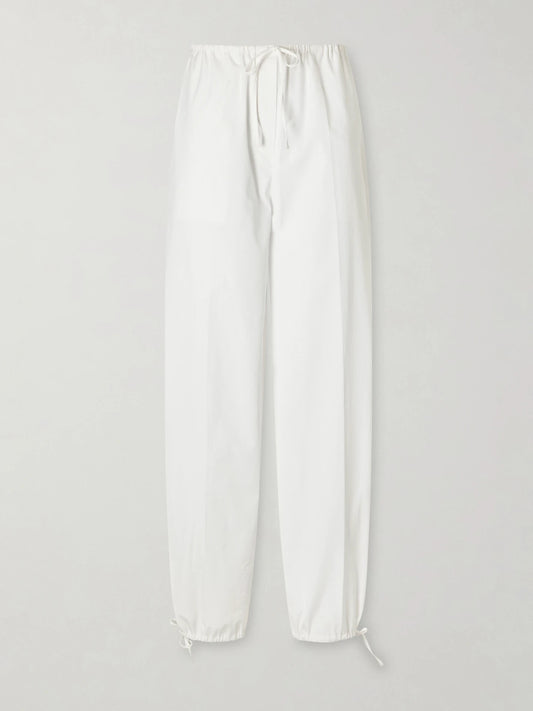 Image of a model wearing Pants. Product name - Cotton Wide-leg Drawstring Balloon Pants in White colour by brand - TOTEME