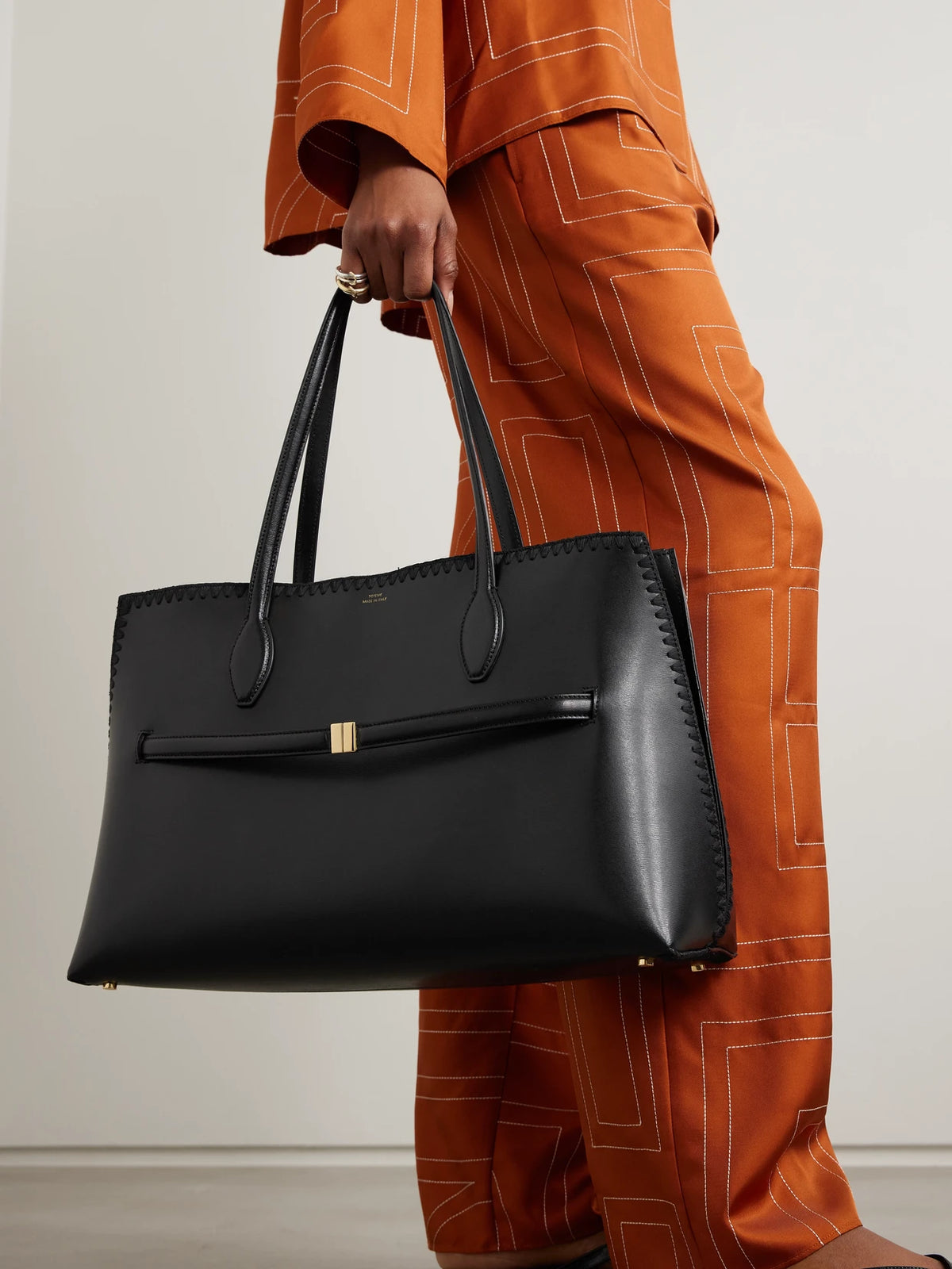 Image of Bags. Product name - Lounge Belted Whipstitched Leather Tote in Black colour by brand - TOTEME