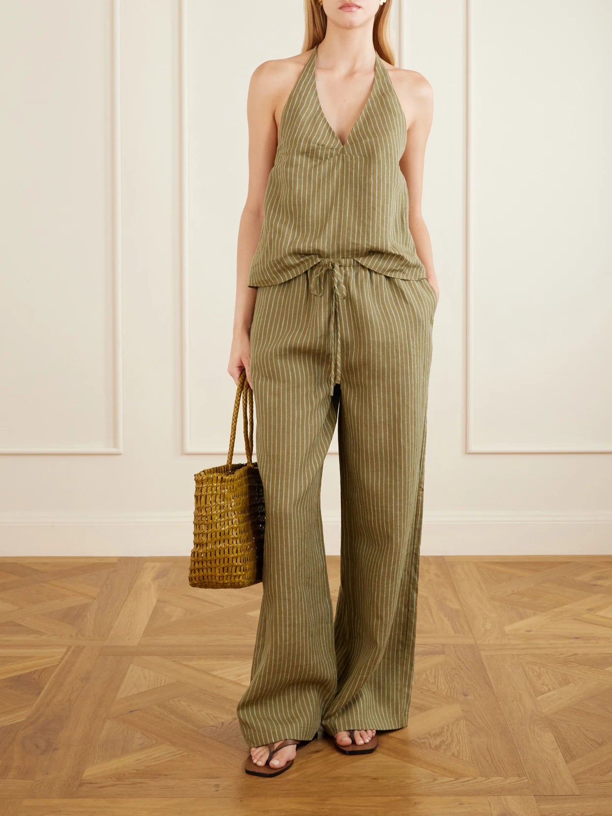 Image of a model wearing Tops. Product name - Corso Striped Linen Halterneck Top in Army green colour by brand - STAUD