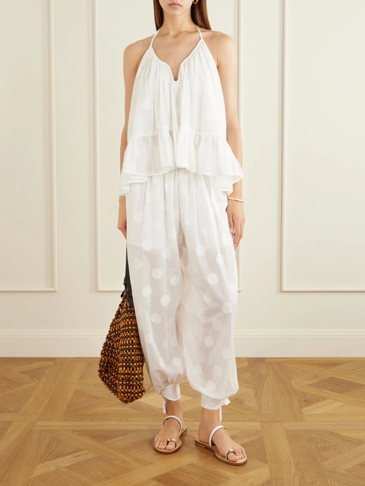 Image of a model wearing Tops. Product name - Solstice Embellished Polka-dot Cotton Tank in Ivory colour by brand - Zimmermann