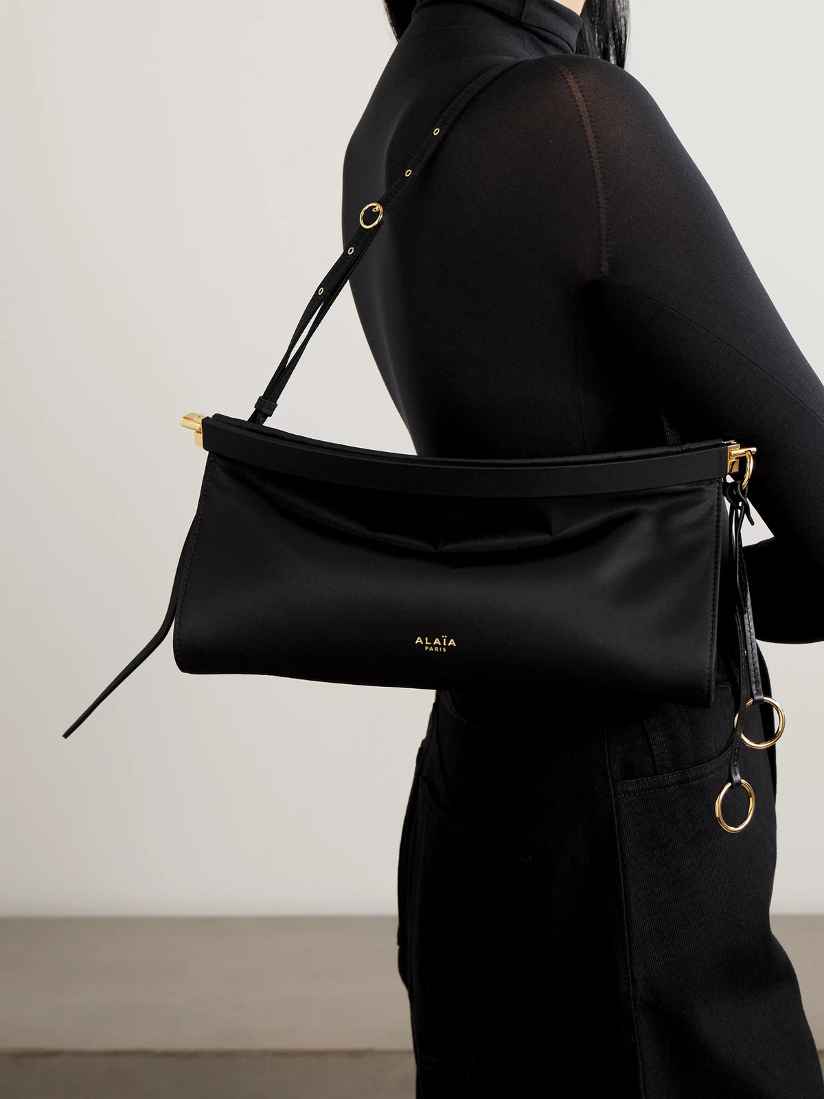 Image of Bags. Product name - Click E/w Large Leather-trimmed Shell Shoulder Bag in Black colour by brand - Alaïa