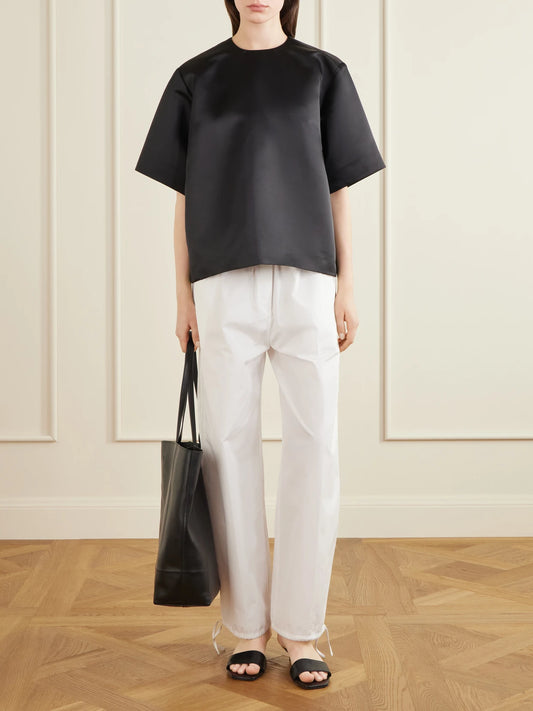 Image of a model wearing Tops. Product name - Duchesse-satin Blouse in Black colour by brand - TOTEME