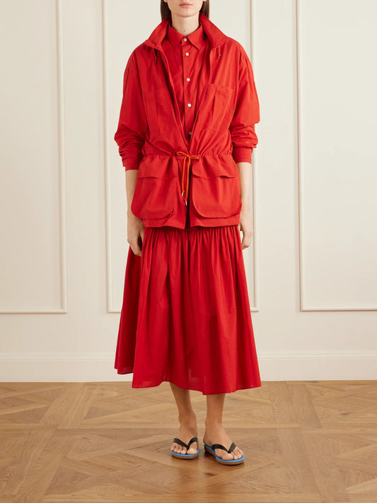 Image of a model wearing Skirts. Product name - Pleated Cotton-poplin Midi Skirt in Red colour by brand - Auralee