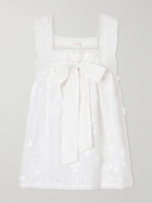 Image of a model wearing Tops. Product name - Suvereto Bow-embellished Lace-trimmed Broderie Anglaise Cotton Top in White colour by brand - Loretta Caponi