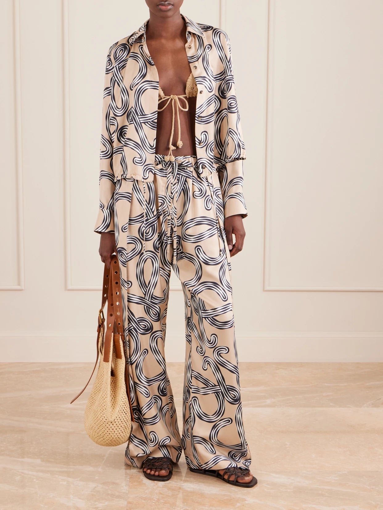 Image of a model wearing Pants. Product name - + Paula's Ibiza Printed Mid-rise Straight-leg Silk Pants in Beige colour by brand - LOEWE
