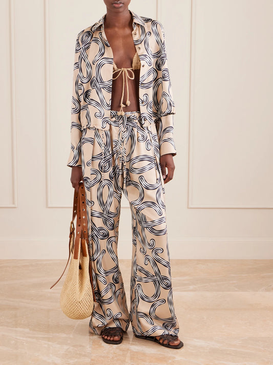 Image of a model wearing Pants. Product name - + Paula's Ibiza Printed Mid-rise Straight-leg Silk Pants in Beige colour by brand - LOEWE