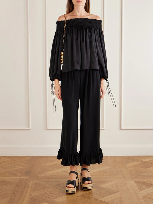 Image of a model wearing Pants. Product name - Ruffled Silk Crepe De Chine Wide-leg Pants in Black colour by brand - Chloé