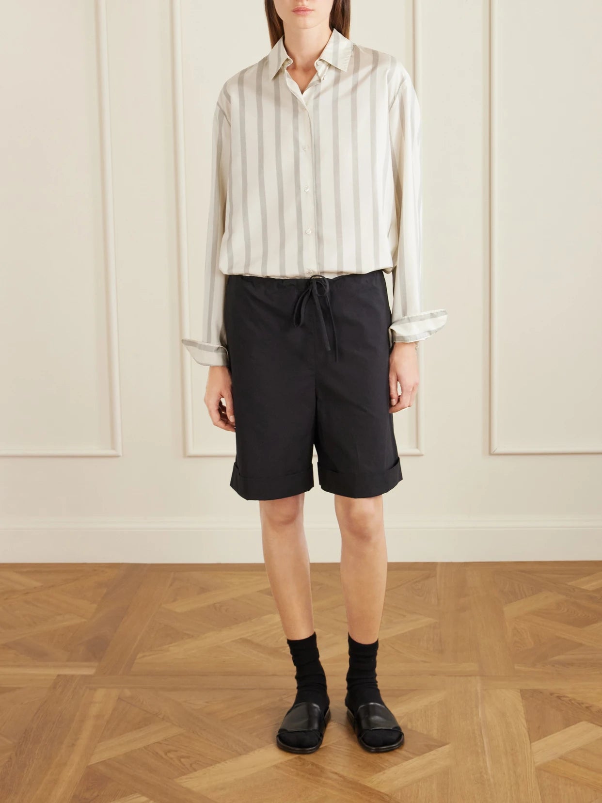 Image of a model wearing Tops. Product name - Sisilia Oversized Pinstriped Silk-twill Shirt in Beige colour by brand - The Row