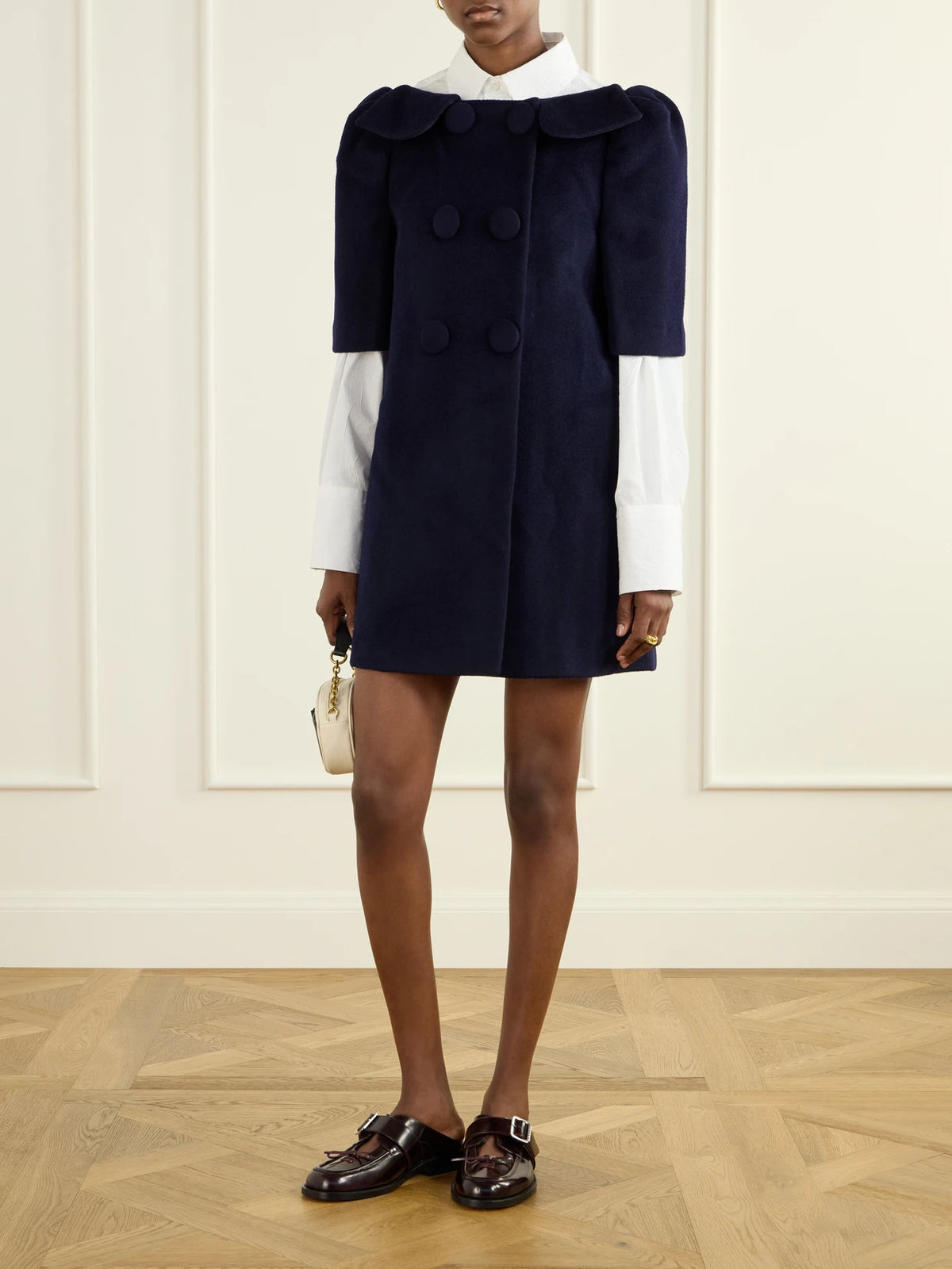 Image of a model wearing Skirts. Product name - Bow-detailed Wool-ponte Mini Skirt in Navy colour by brand - SHUSHU/TONG