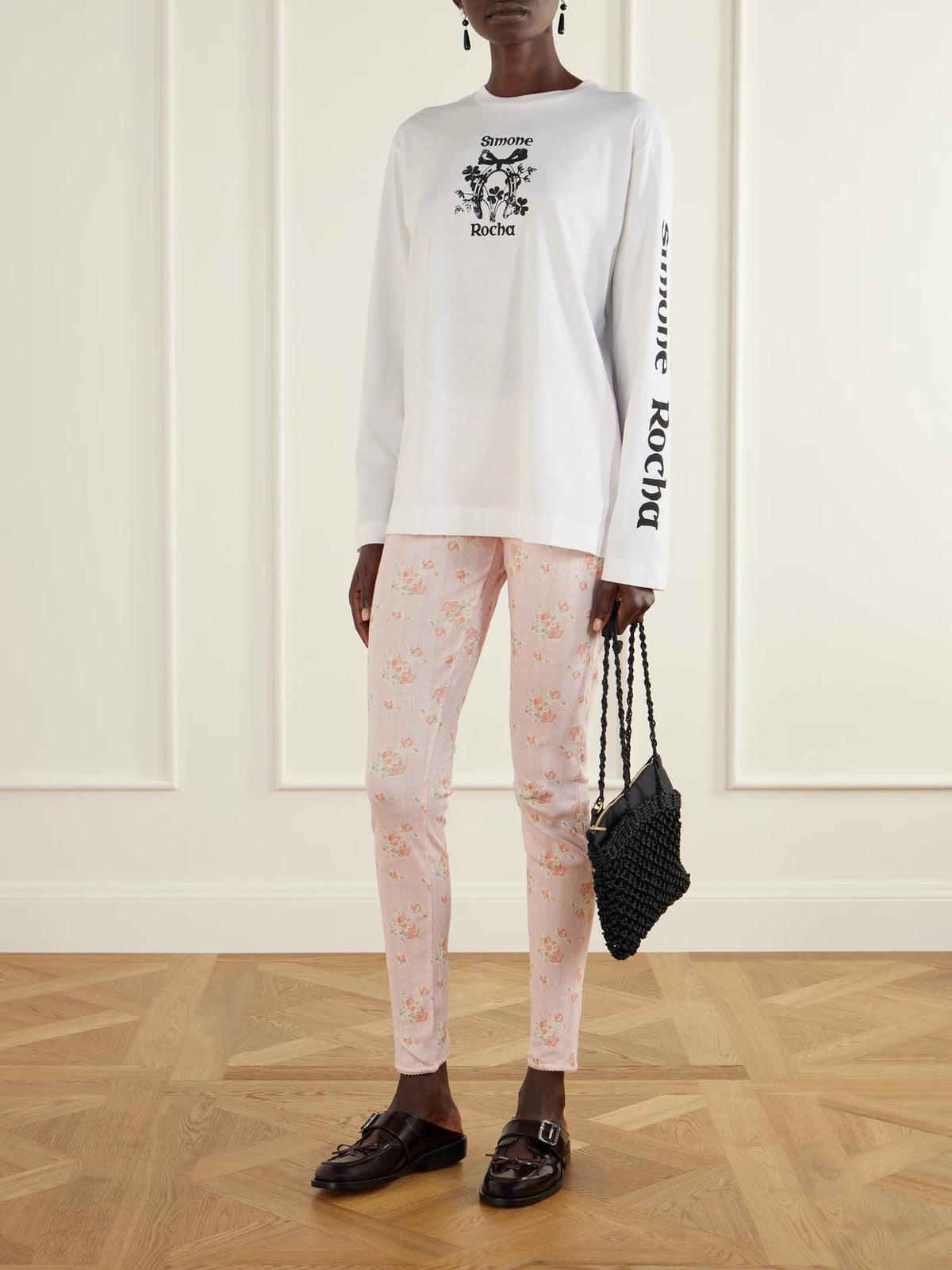 Image of a model wearing Pants. Product name - Ruffled Floral-print Pointelle-knit Cotton-jersey Leggings in Pastel pink colour by brand - Simone Rocha
