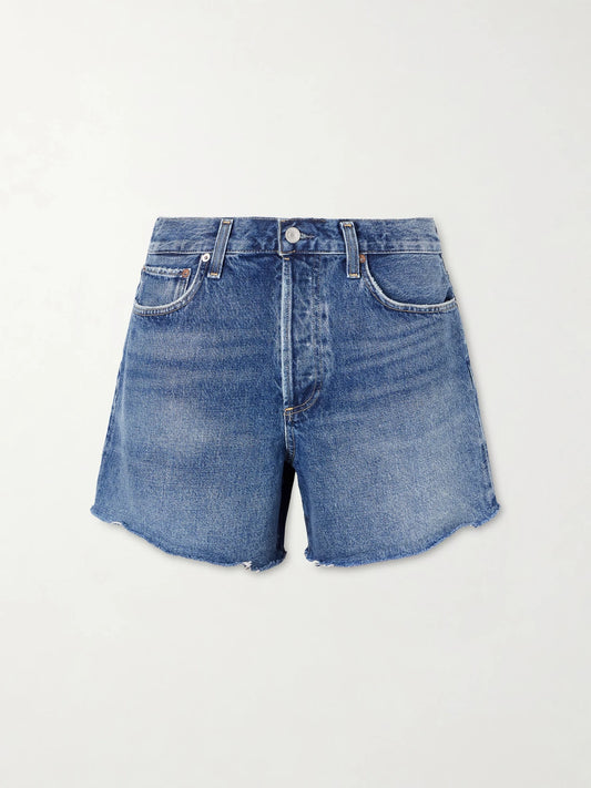 Image of a model wearing Shorts. Product name - Nye Frayed Denim Shorts in Dark denim colour by brand - AGOLDE