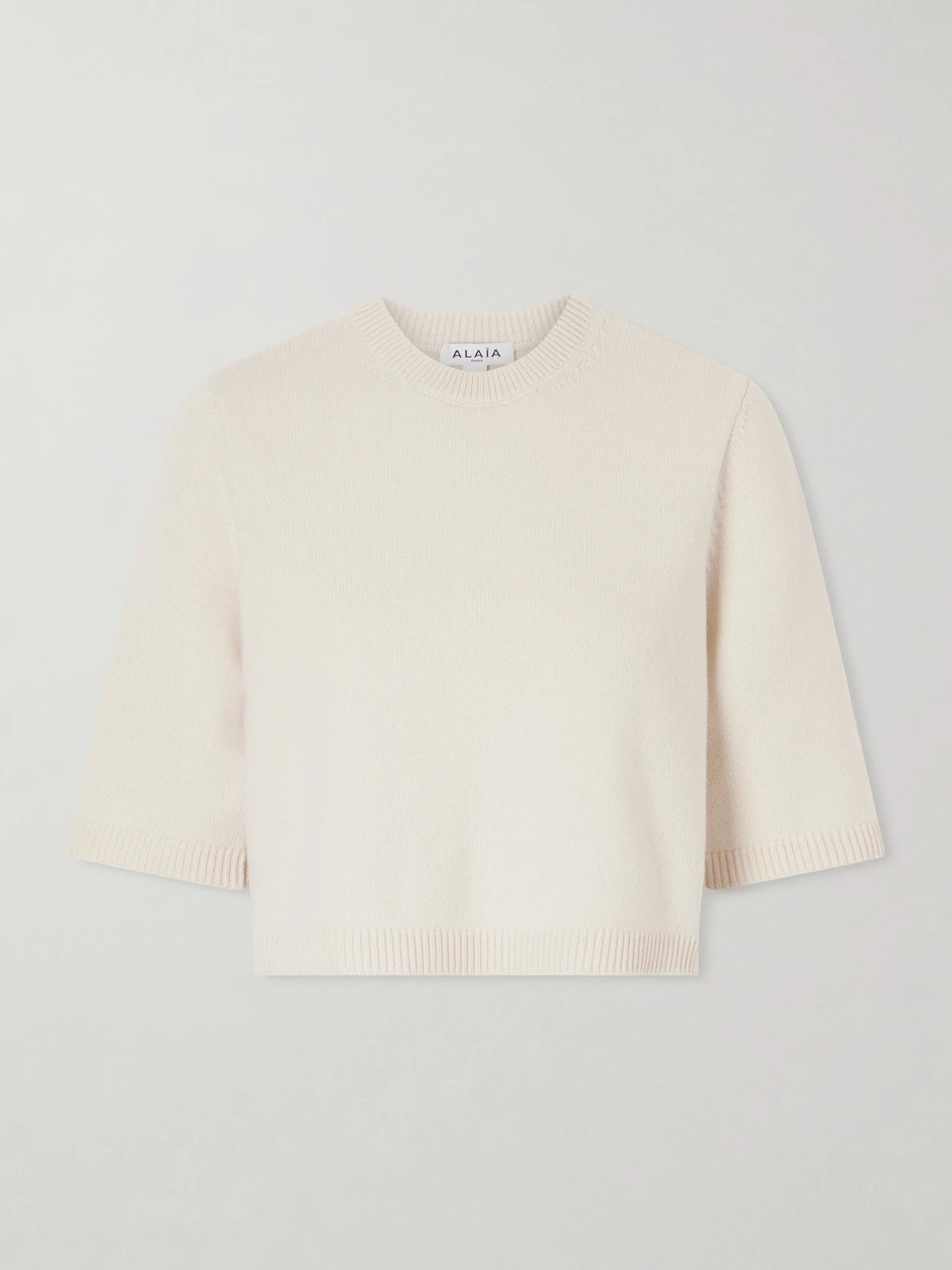 Image of a model wearing Outerwear. Product name - Cropped Cashmere-blend Sweater in White colour by brand - Alaïa