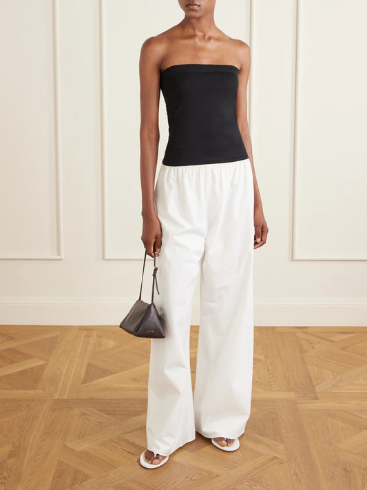 Image of a model wearing Tops. Product name - Bes Strapless Organic Cotton-jersey Top in Black colour by brand - FLORE FLORE