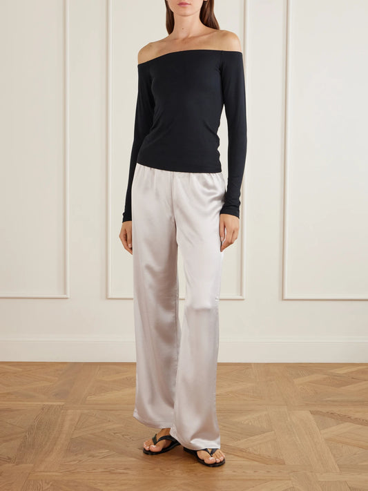 Image of a model wearing Tops. Product name - Smooth Layers Off-the-shoulder Top - Obsidian in Black colour by brand - SKIMS