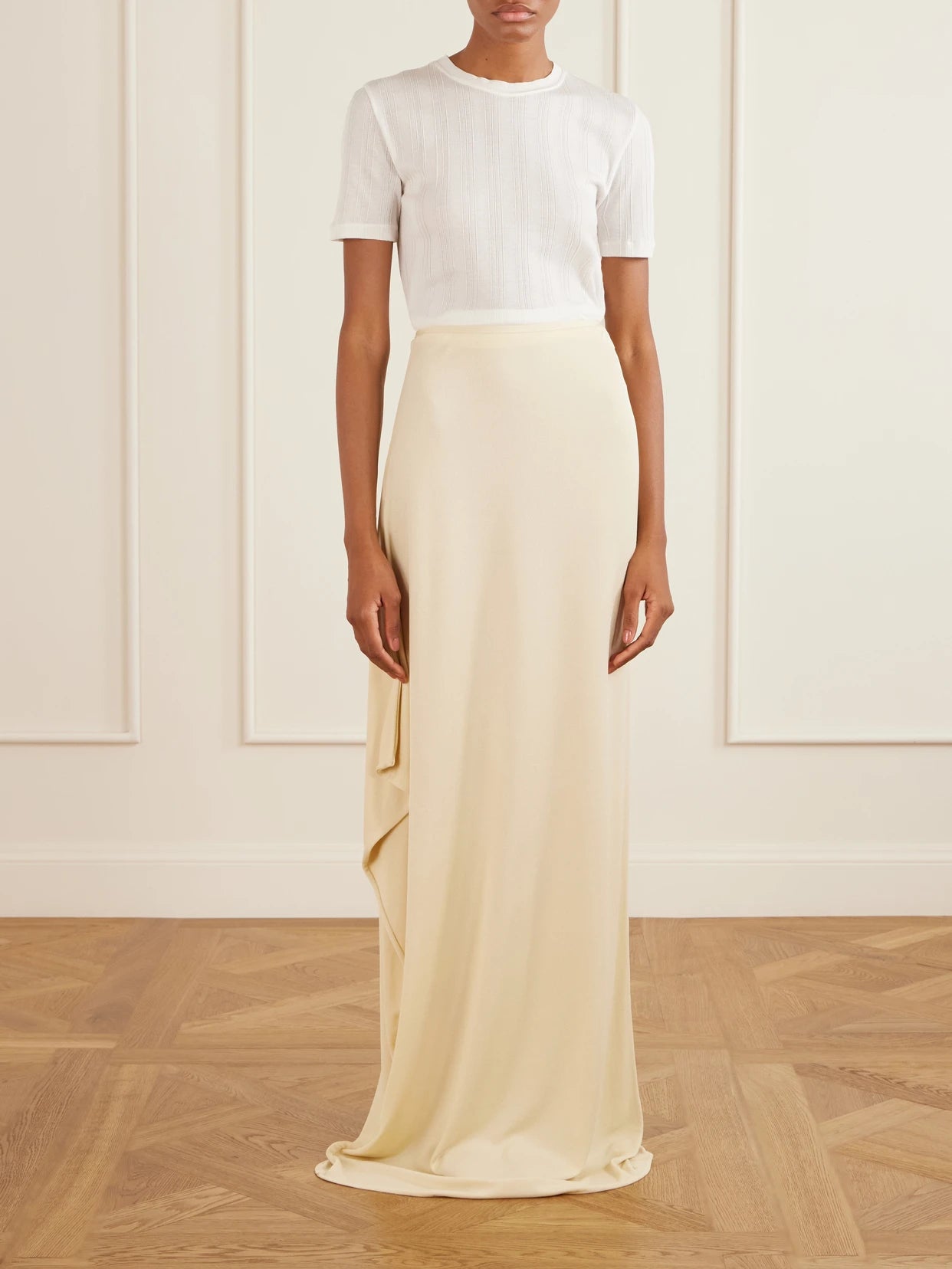 Image of a model wearing Skirts. Product name - Dione Satin Maxi Skirt in Cream colour by brand - The Row