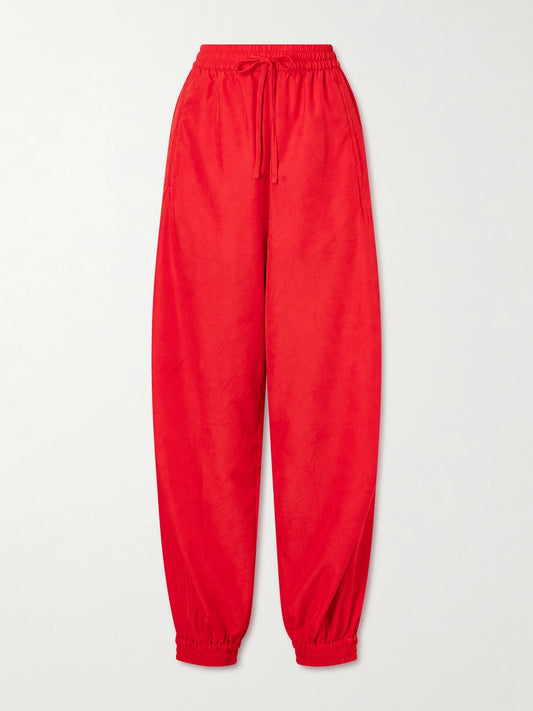 Image of a model wearing Pants. Product name - Crinkled Cotton-blend Balloon Pants in Red colour by brand - RÓHE