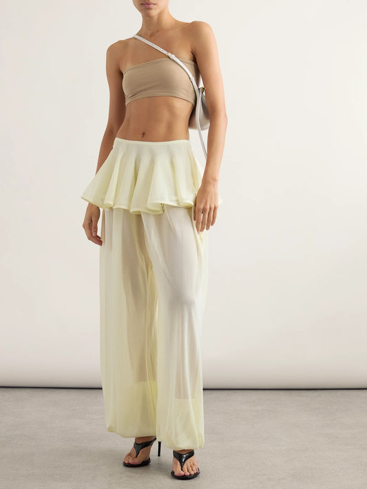 Image of a model wearing Pants. Product name - Pleated Georgette Peplum Balloon Pants in Pastel yellow colour by brand - Alaïa