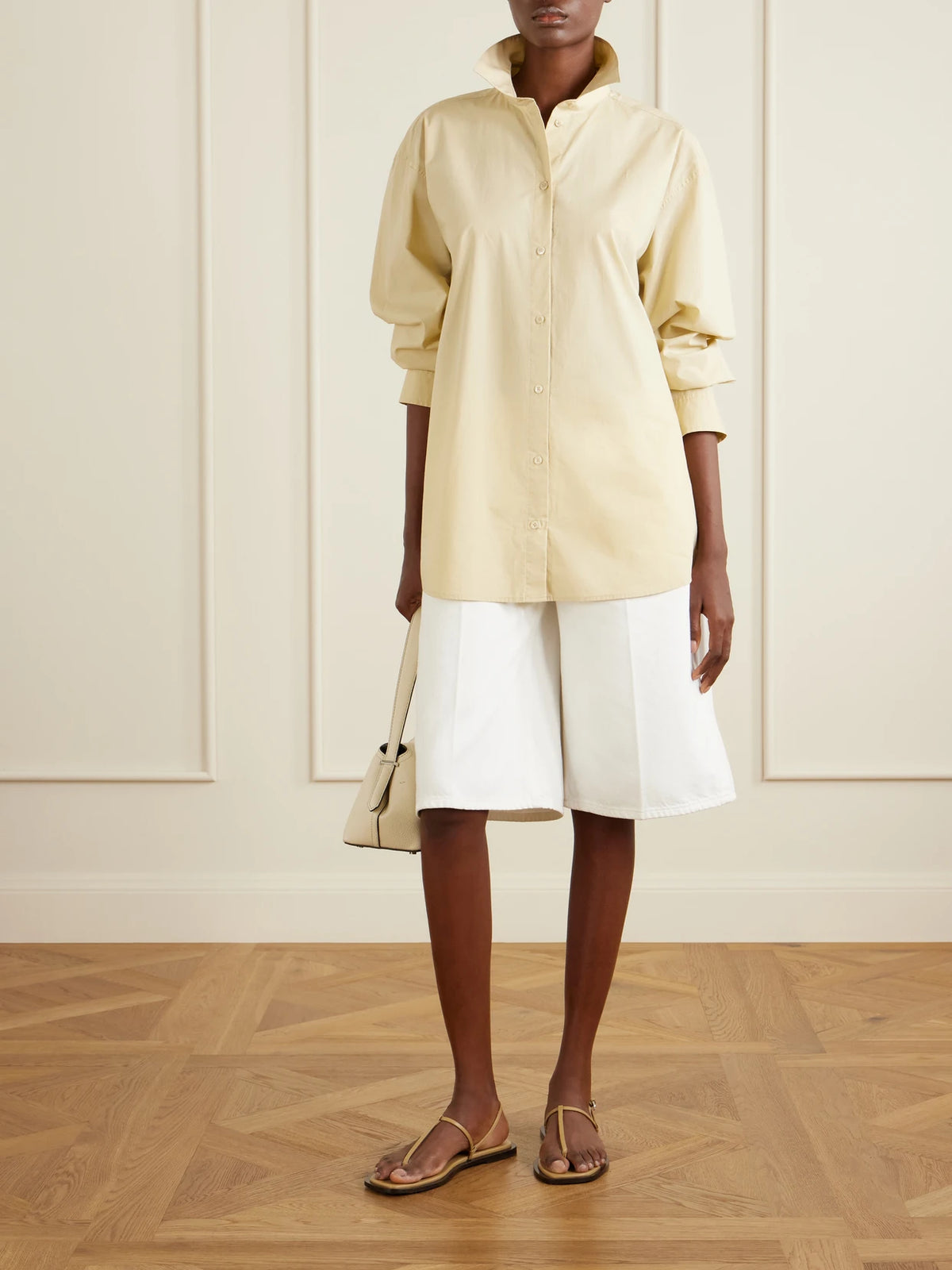 Image of a model wearing Tops. Product name - Cotton Shirt in Cream colour by brand - TOTEME