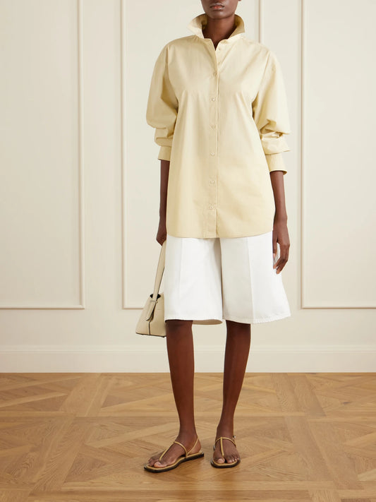 Image of a model wearing Tops. Product name - Cotton Shirt in Cream colour by brand - TOTEME