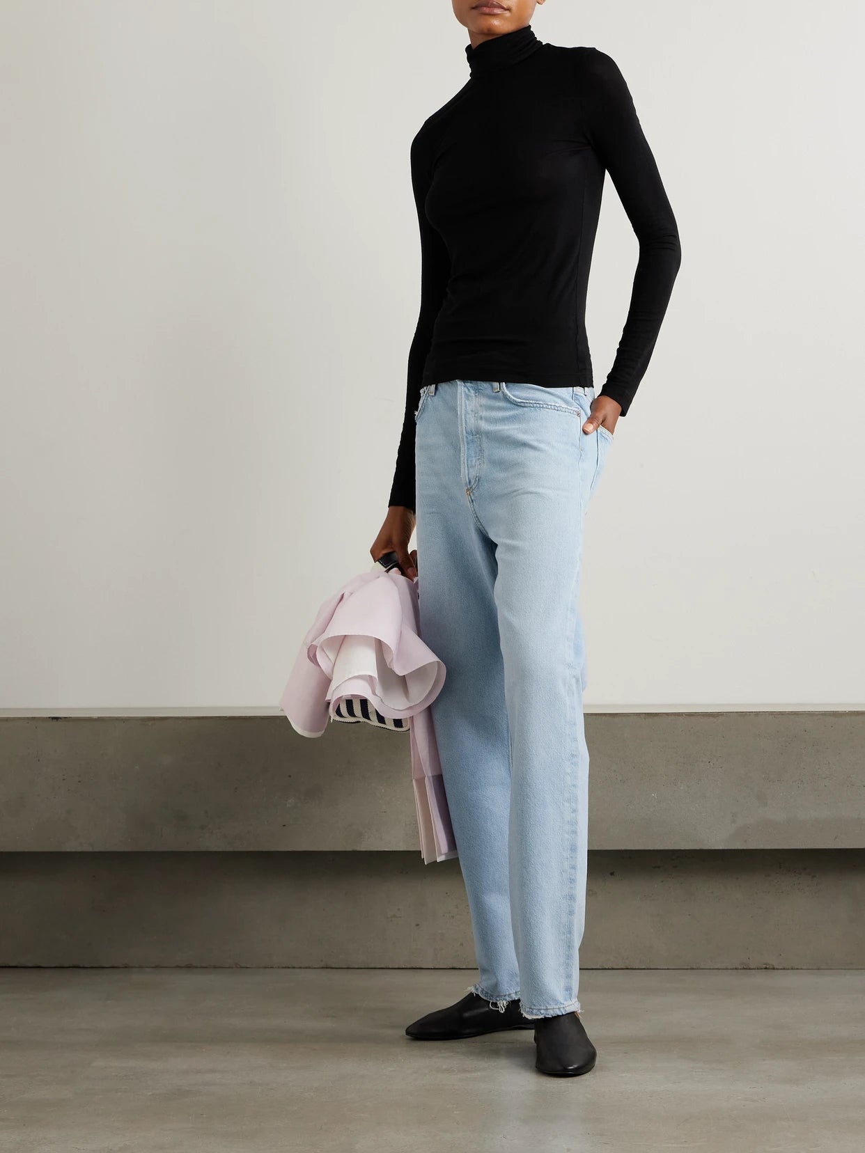 Image of a model wearing Tops. Product name - Pascale Stretch-lyocell Turtleneck Top in Black colour by brand - AGOLDE