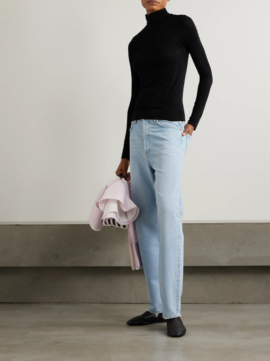 Image of a model wearing Tops. Product name - Pascale Stretch-lyocell Turtleneck Top in Black colour by brand - AGOLDE