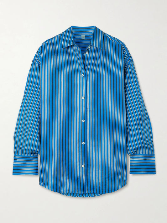 Image of a model wearing Tops. Product name - Oversized Striped Silk-twill Shirt in Blue colour by brand - TOTEME