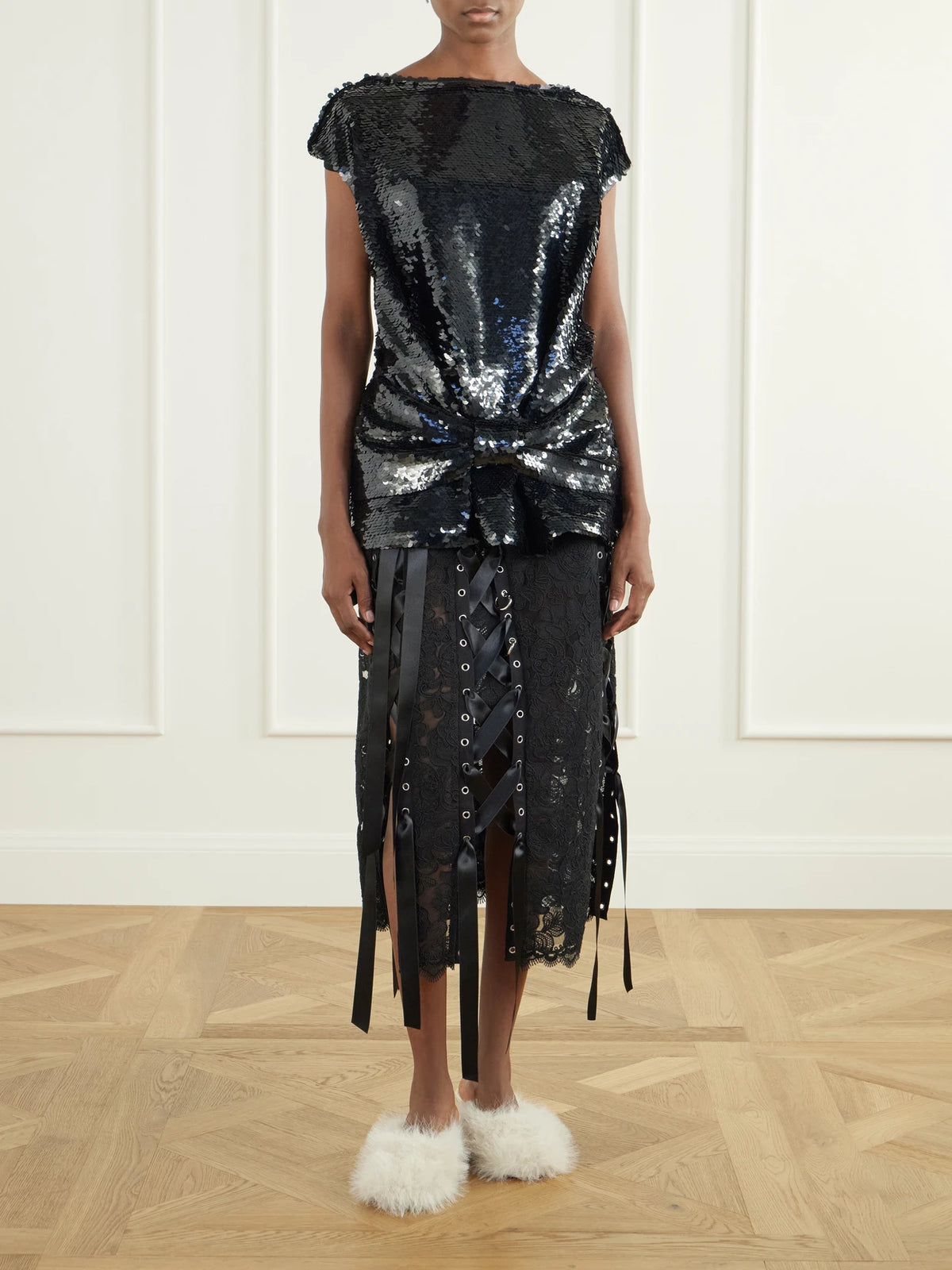 Image of a model wearing Skirts. Product name - Unraveling Ribbon Ring Asymmetric Embellished Lace And Satin Midi Skirt in Black colour by brand - Simone Rocha