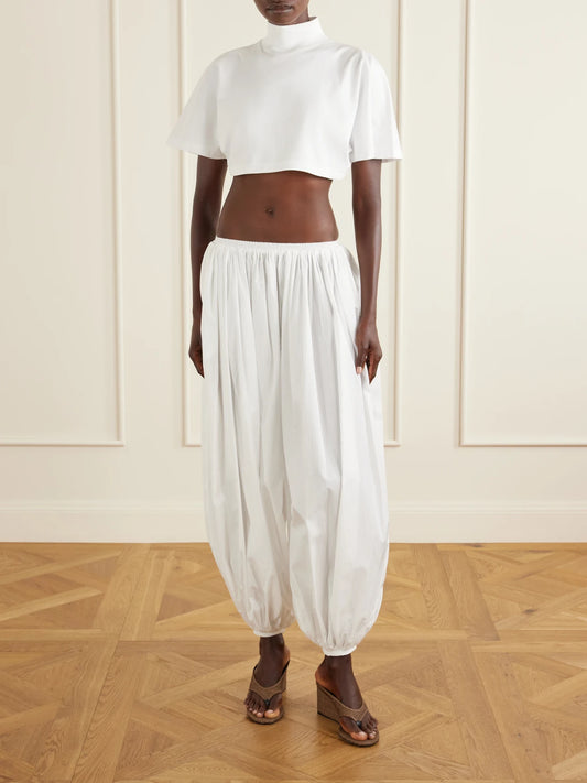 Image of a model wearing Tops. Product name - Cropped Cotton-jersey Turtleneck T-shirt in White colour by brand - Alaïa