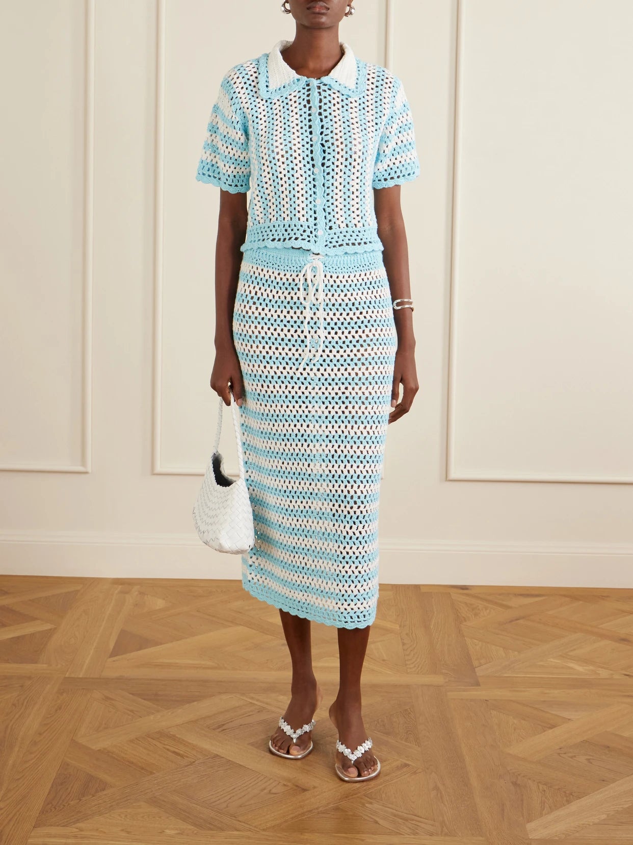Image of a model wearing Skirts. Product name - Welles Striped Crocheted Cotton Midi Skirt in Blue colour by brand - SIMKHAI
